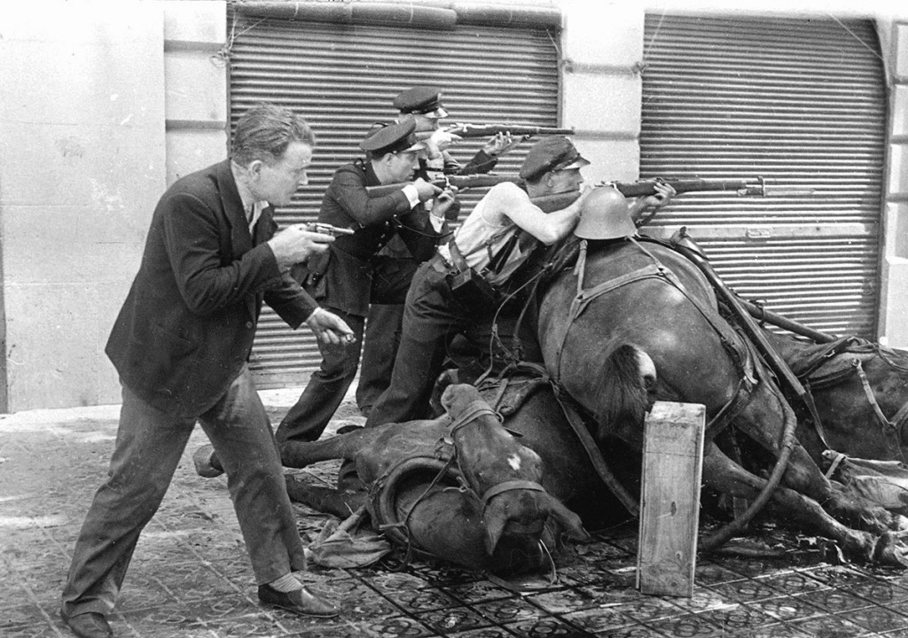 Mariano Vitini en el centro disparando apoyado en un caballo muerto, en la famosa fotografía de Agustí Centelles tomada en Barcelona al inicio de la Guerra Civil.