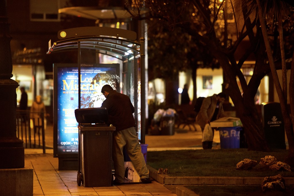 Dos hombres rebuscan entre la basura, una escena cotidiana en la noche ovetense y de cualquier ciudad española. Foto / Iván Martínez.