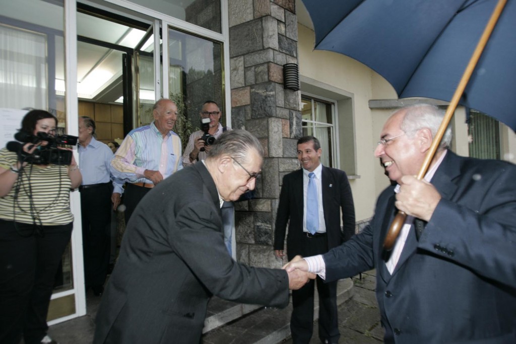 Juan Velarde recibe efusivamente en La Granda al entonces presidente asturiano Vicente Álvarez Areces durante los actos del 30 aniversario de los cursos. Al fondo, en la puerta, Teodoro López Cuesta. Foto / Miki López.