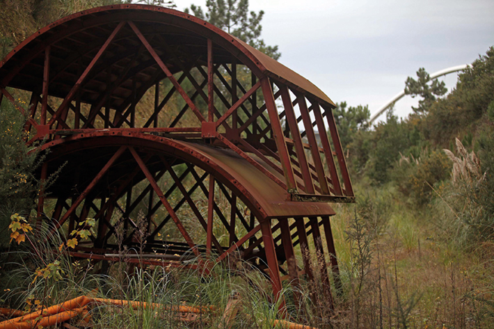 Restos del material usado para construir en túnel del ramal, abandonados y cubiertos de maleza. Foto / Sergio López.